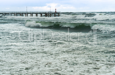 a storm at sea, the waves cover the pier