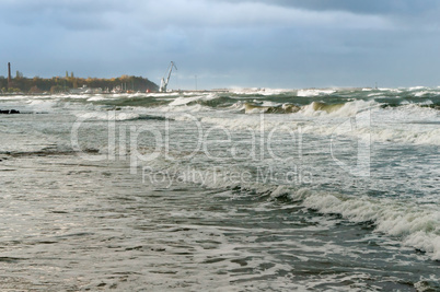 the waves cover the pier, a severe storm in the Baltic sea