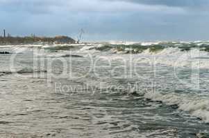 the waves cover the pier, a severe storm in the Baltic sea