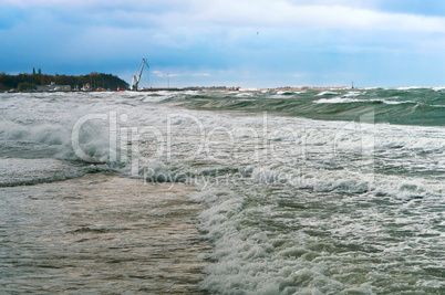 a storm at sea, the waves cover the pier, a severe storm in the Baltic sea