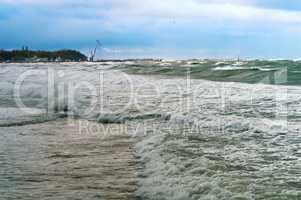 a storm at sea, the waves cover the pier, a severe storm in the Baltic sea