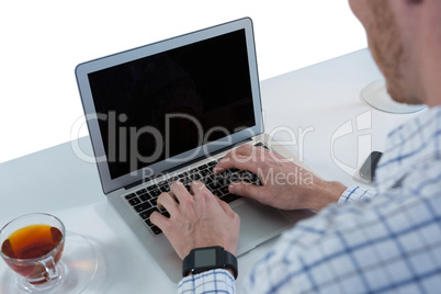 Male executive using laptop at desk