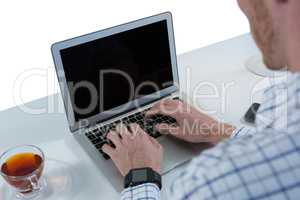 Male executive using laptop at desk