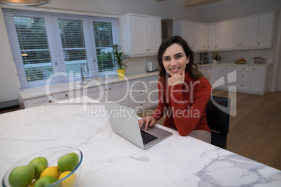 Woman using laptop in kitchen