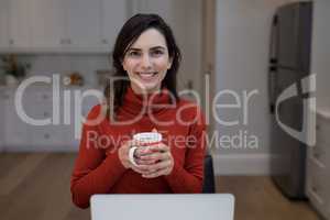 Woman using laptop while having coffee