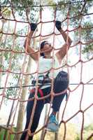 Determined woman climbing net