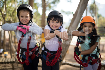 Portrait of happy kids leaning on cable