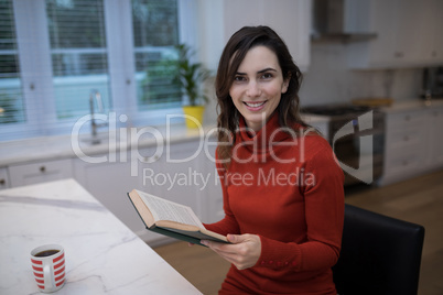 Beautiful woman reading book at table