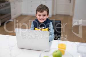 Boy using laptop in kitchen