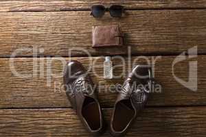 Shoes, perfume, wallet and sunglasses on wooden plank