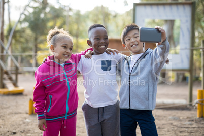 Happy kids taking selfie with mobile phone