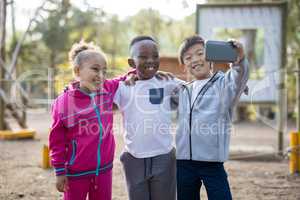 Happy kids taking selfie with mobile phone