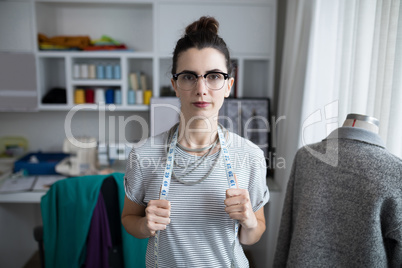 Fashion designer standing with measuring tape
