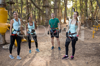 Happy coach and trainee standing in forest