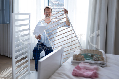 Man making cot in bedroom