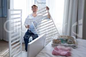Man making cot in bedroom