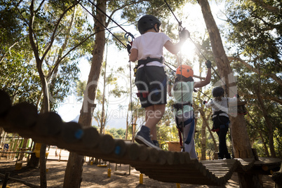 Determined kids crossing zip line