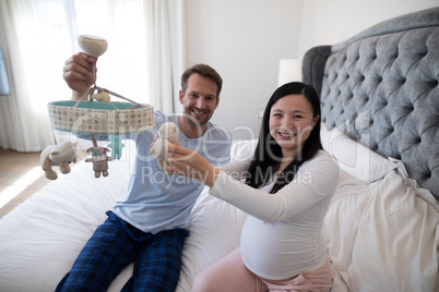 Portrait of man and pregnant woman holding toy