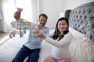 Portrait of man and pregnant woman holding toy