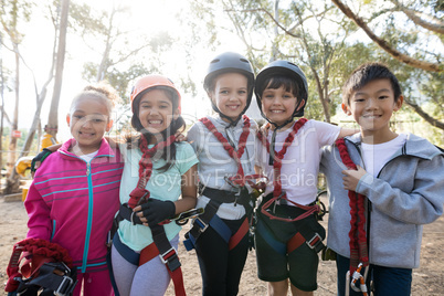 Happy kids standing with arm around on a sunny day