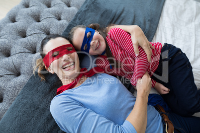 Mother and daughter lying on bed