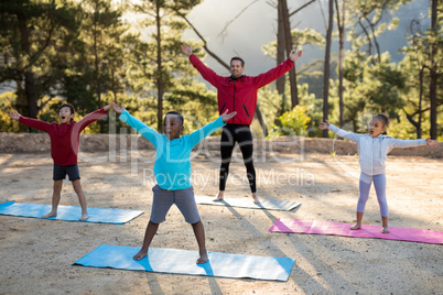 Coach assisting kids in practicing yoga