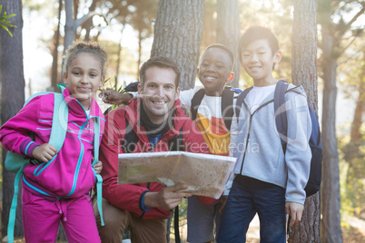 Portrait of teacher and kids reading map