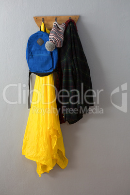 Raincoat, warm clothing and bag hanging on hook