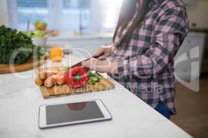 Pregnant woman chopping vegetables in kitchen