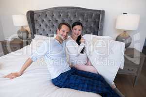 Portrait of happy couple holding picture of teddy bear