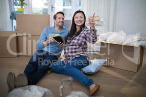 Couple using digital tablet at their new home