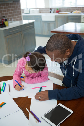 Father helps his daughter with her school homework