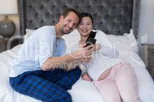 Happy couple reviewing picture on mobile phone