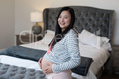 Portrait of pregnant woman touching her stomach