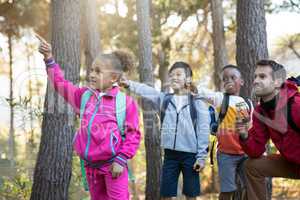 Kids pointing at distance in forest
