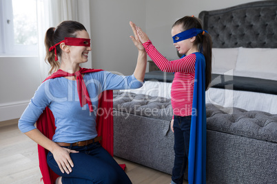 Mother and daughter giving high five to each other