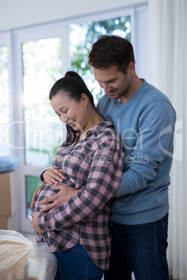 Man touching womans pregnant belly at new house