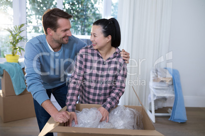 Couple unpacking boxes in new home