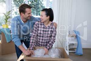 Couple unpacking boxes in new home