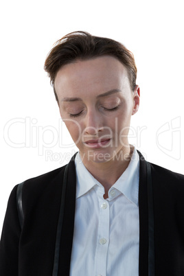 Businesswoman standing with eyes closed against white background