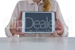Female executive holing digital tablet at desk