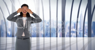 Businesswoman covering eyes with hand in city office