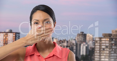 Businesswoman covering mouth with hand in city