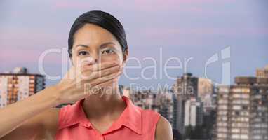 Businesswoman covering mouth with hand in city