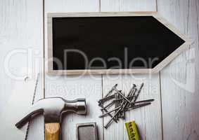 Blackboard arrow sign on wood with tools