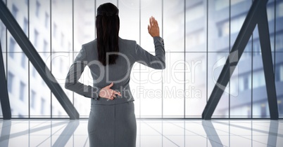Businesswoman swearing honesty with hand and fingers crossed behind back in city office