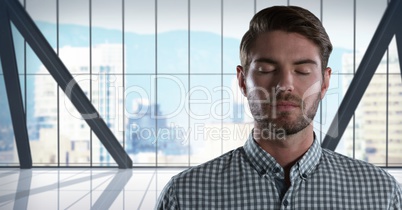 Businessman with eyes closed in city office