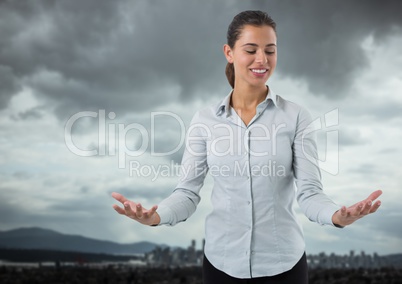 Businesswoman with hands palm open in city landscape and sky