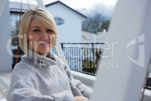 Portrait of beautiful woman sitting in porch