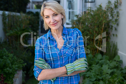 Portrait of happy woman standing with hands on hip